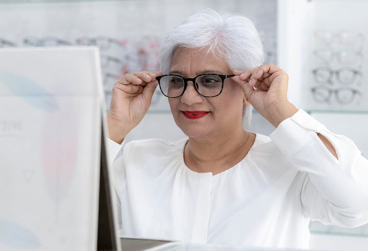 Une femme essaie une paire de lunettes chez un opticien